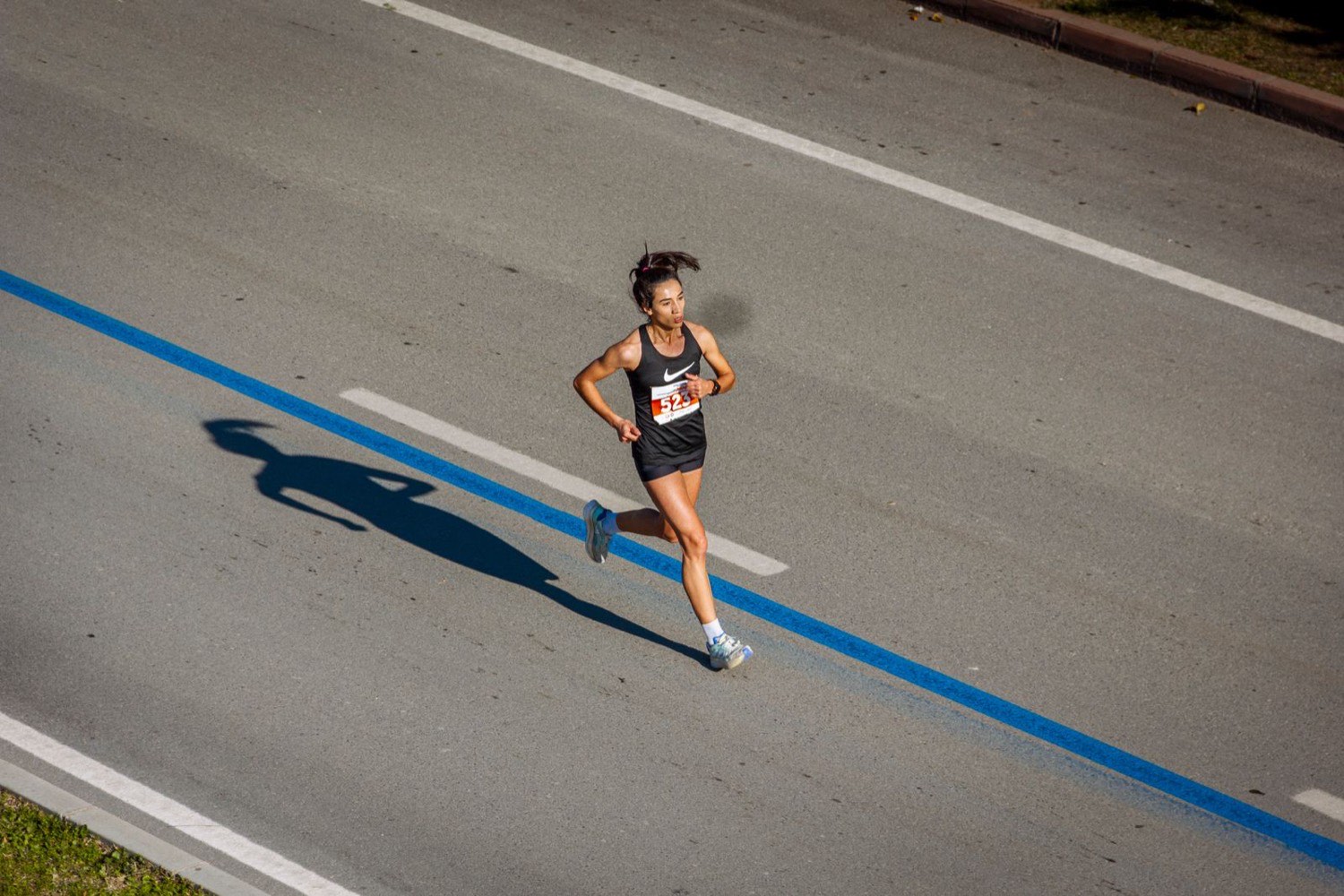 A lone distance runner on an open road, easy aerobic running